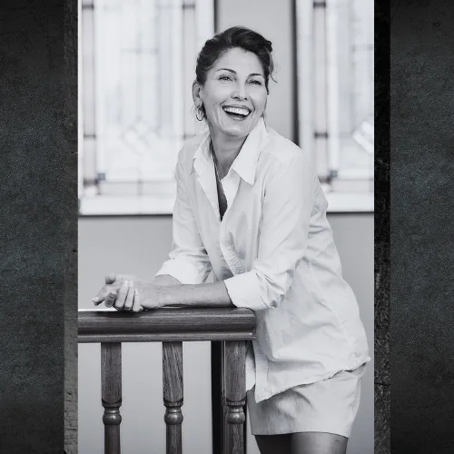 Fleur Warner of AdaptAd leaning on a timber rail, black and white portrait