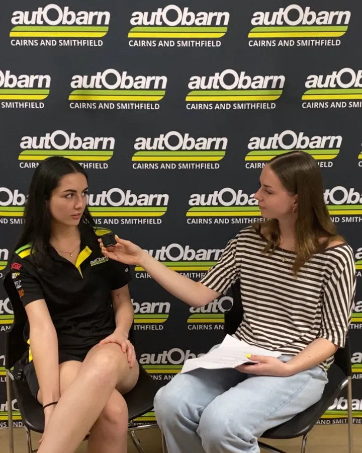 AdaptAd catching up with Zarah from Autobarn Cairns in front of the Autobarn logo wall